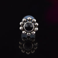 Bioflex PTFE labret with a black onyx stone surrounded by tribal beading on a black background