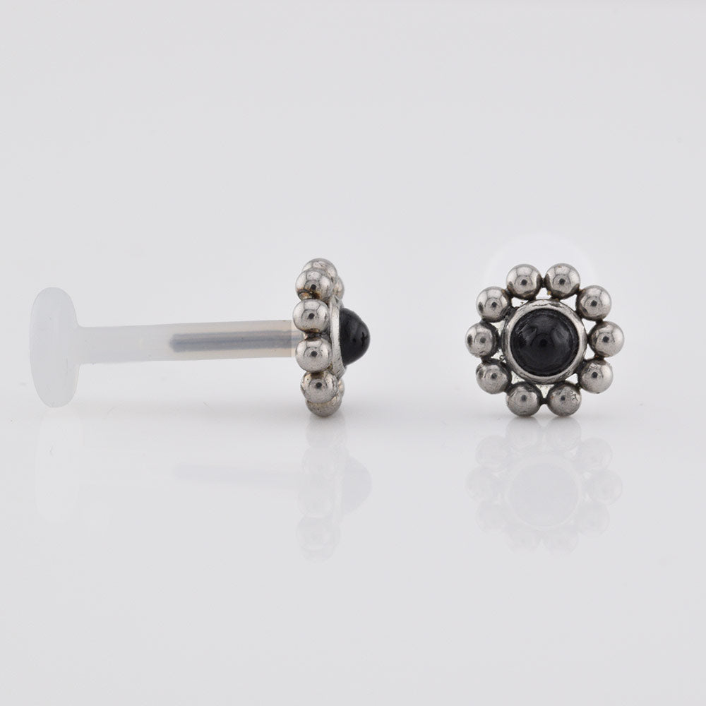 Bioflex PTFE labret with a black onyx stone surrounded by tribal beading on a white background