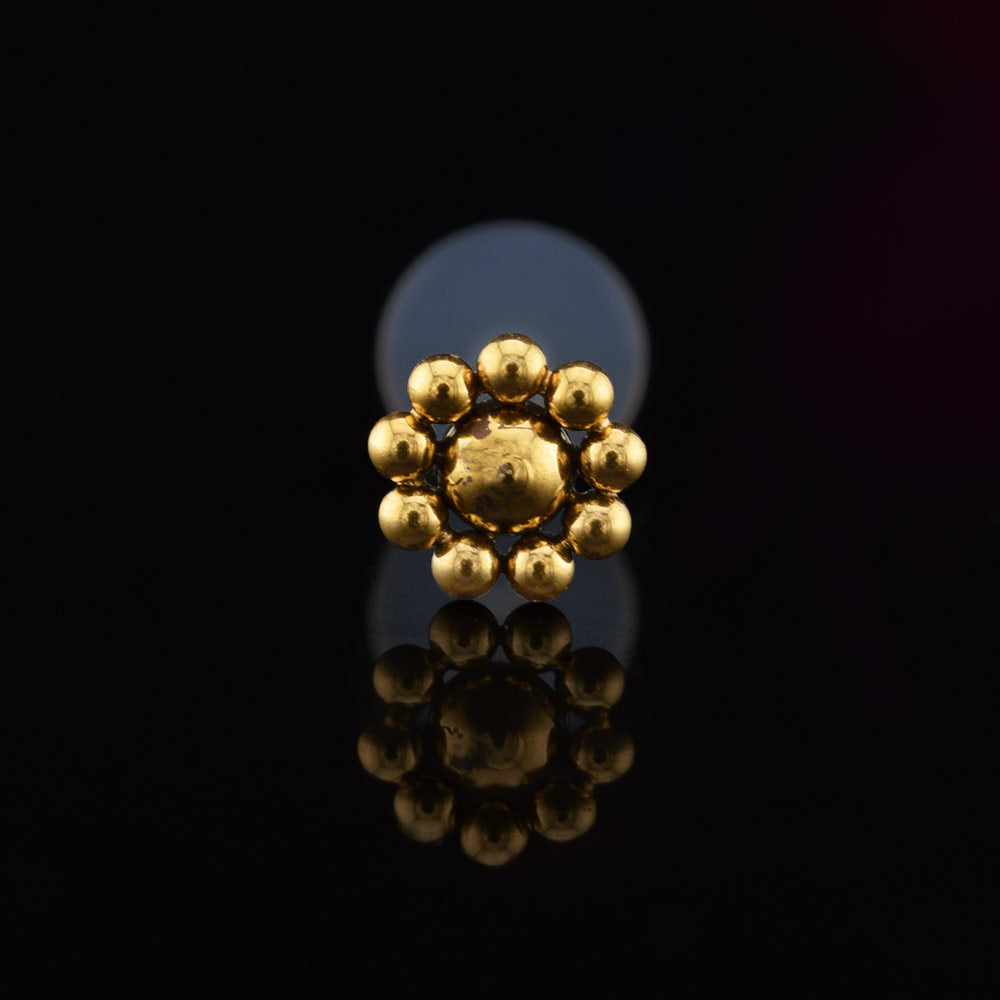 gold steel bioflex ptfe tribal bead labret on a black background