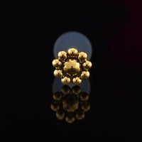 gold steel bioflex ptfe tribal bead labret on a black background