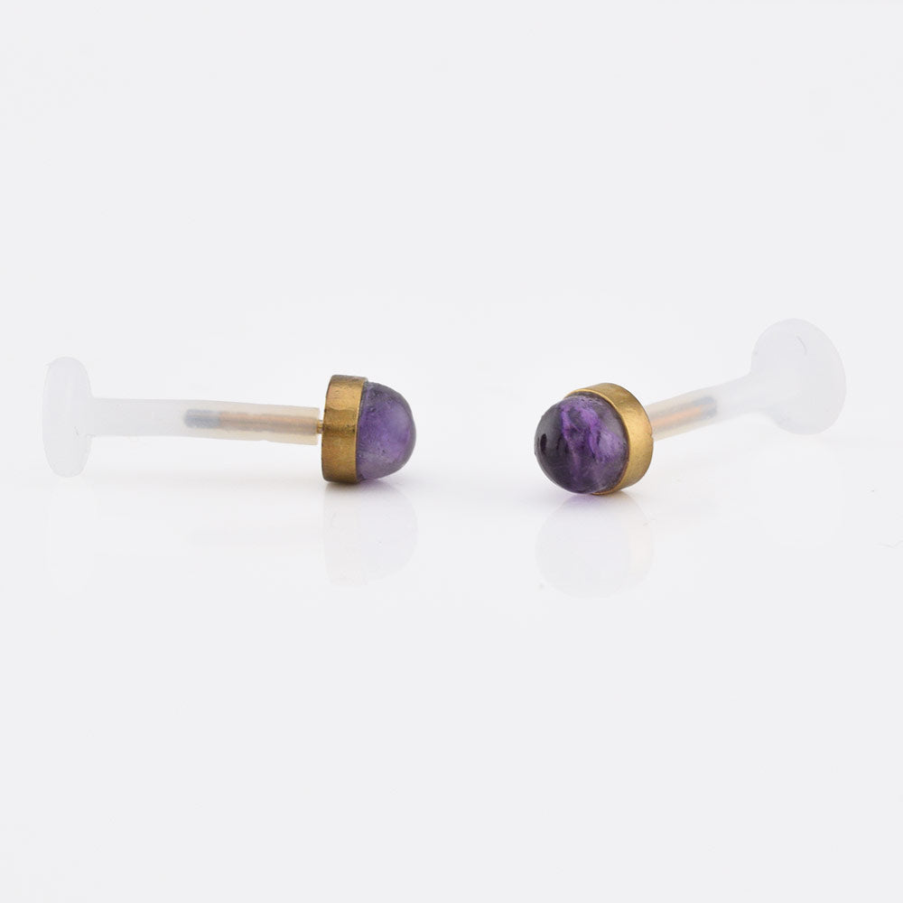 bioflex ptfe labret with an amethyst stone set in a gold steel end on a white background