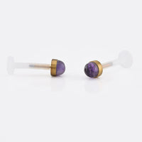 bioflex ptfe labret with an amethyst stone set in a gold steel end on a white background