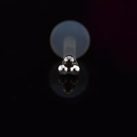 triple dots labret earring on bioflex ptfe bar on a black background