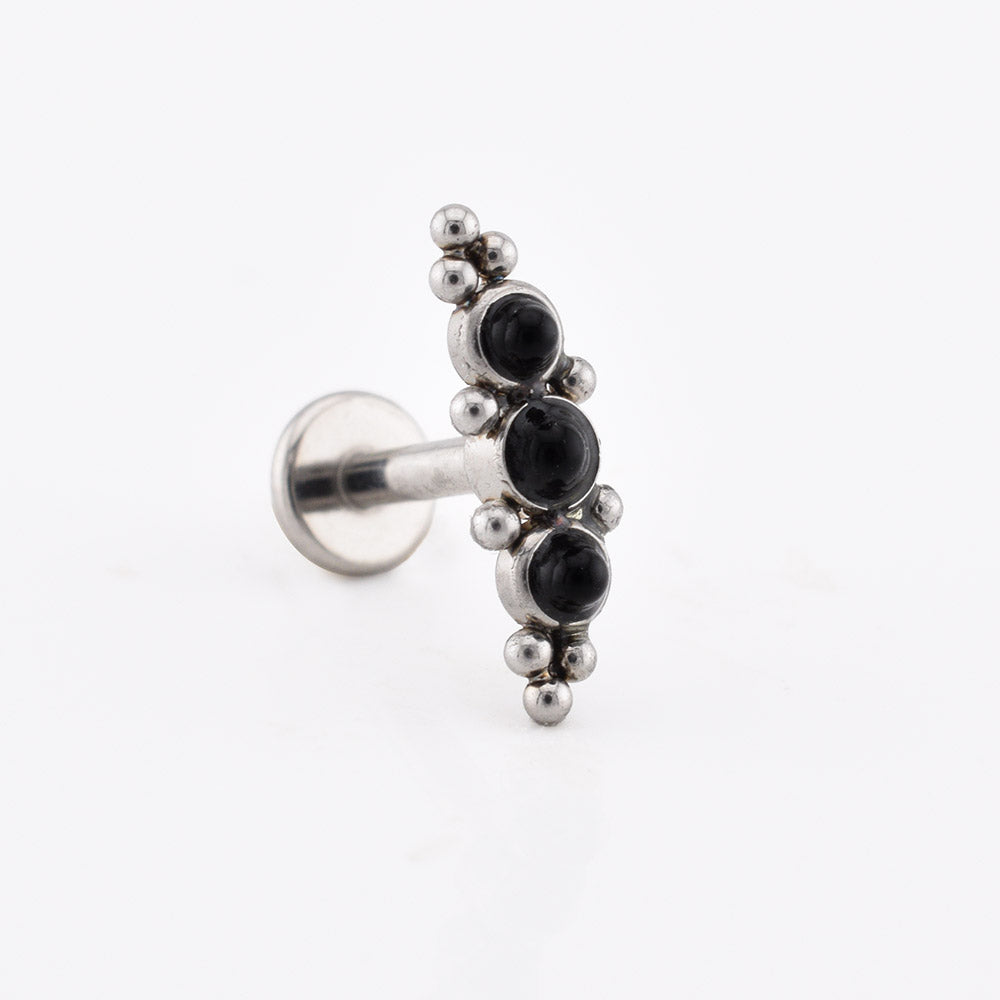 Helix Labret Earring with a cascade of three black onyx stones decorated with tribal beading in surgical steel on a white background
