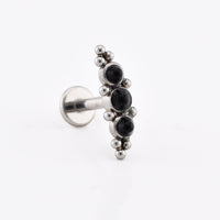 Helix Labret Earring with a cascade of three black onyx stones decorated with tribal beading in surgical steel on a white background