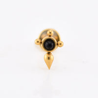 A gold-tonedlabret piercing stud with a central black oval stone, three small gold beads on the sides, and a teardrop-shaped drop below, shown on a plain white background.