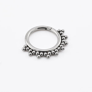 hinged segment clicker ring with tribal beads design on white background