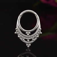 Tribal Clicker RIng aka hinged segment piercing ring in an Indian design on a black background