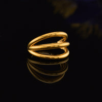 triple stack segment clicker ring in gold steel on a black reflective background