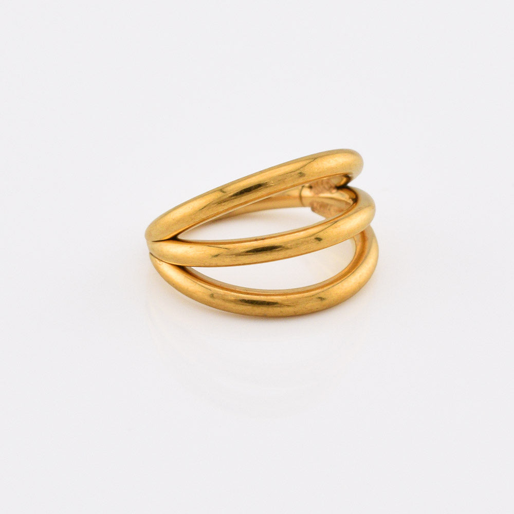 A gold steel hinged segment ring with a polished finish, featuring three curved bands, photographed on a clean white background.