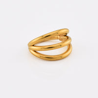 A gold steel hinged segment ring with a polished finish, featuring three curved bands, photographed on a clean white background.