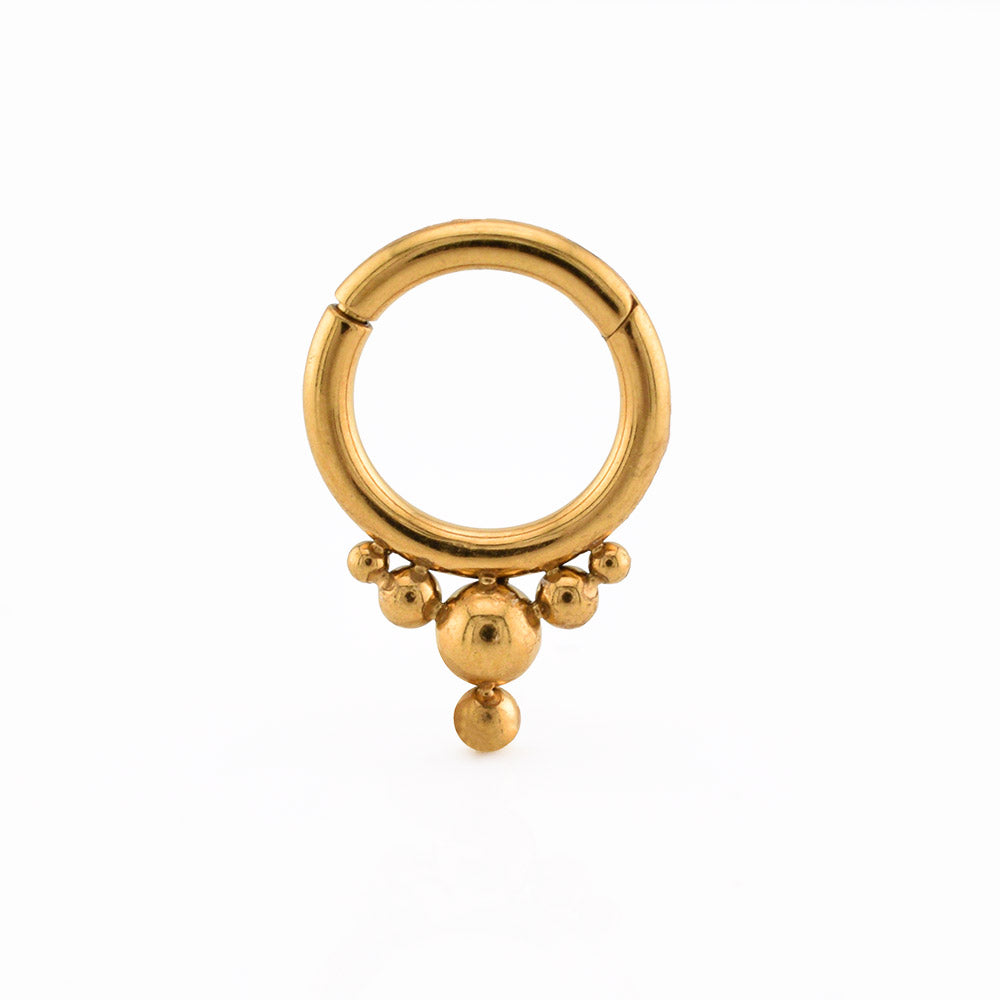 A gold  steel hoop hinged segment clicker ring with a fixed tribal beaded fringe, displayed on a white surface.